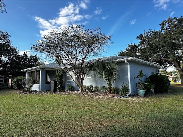 view of property exterior featuring a lawn and a sunroom