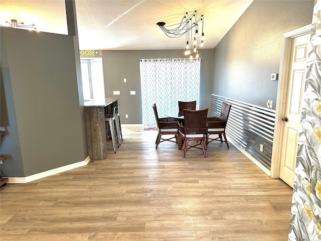 dining space with light wood-type flooring and a notable chandelier