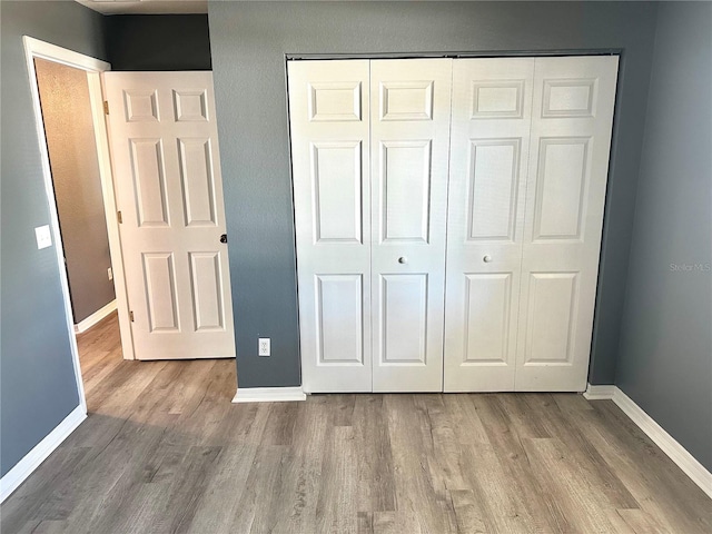 unfurnished bedroom with a closet and light hardwood / wood-style floors