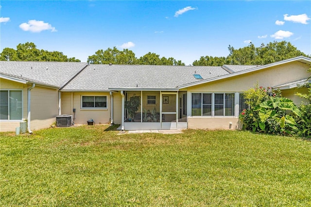 back of house with a lawn, central air condition unit, and a sunroom