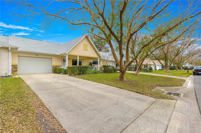 single story home featuring a front lawn, covered porch, and a garage