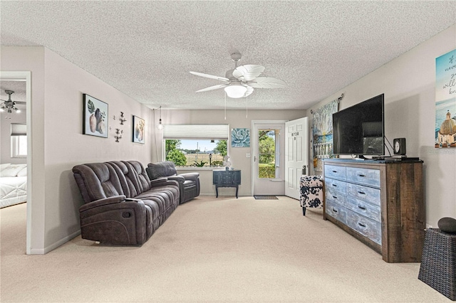 living room with ceiling fan, a textured ceiling, and light carpet