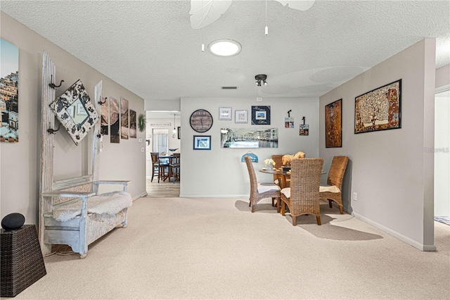 dining area featuring a textured ceiling and carpet flooring