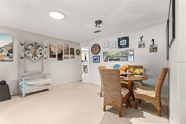 dining area featuring a textured ceiling and carpet flooring