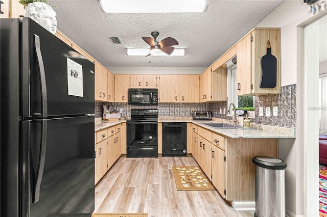 kitchen with a textured ceiling, black appliances, light brown cabinetry, sink, and ceiling fan