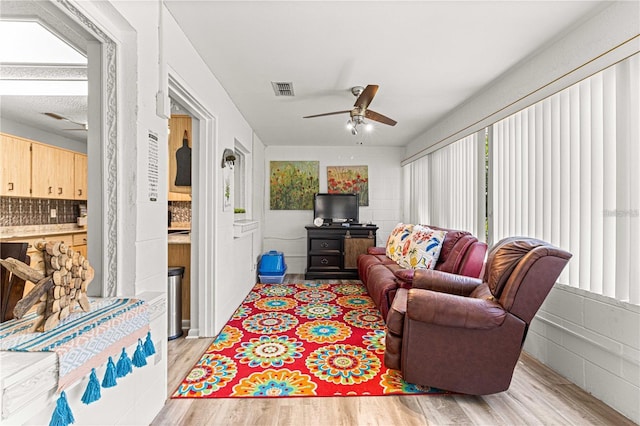 living room featuring ceiling fan and light hardwood / wood-style flooring