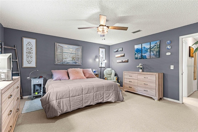 carpeted bedroom featuring ceiling fan and a textured ceiling