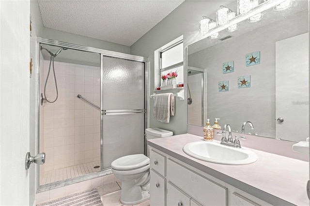 bathroom featuring a shower with shower door, vanity, tile patterned flooring, and a textured ceiling