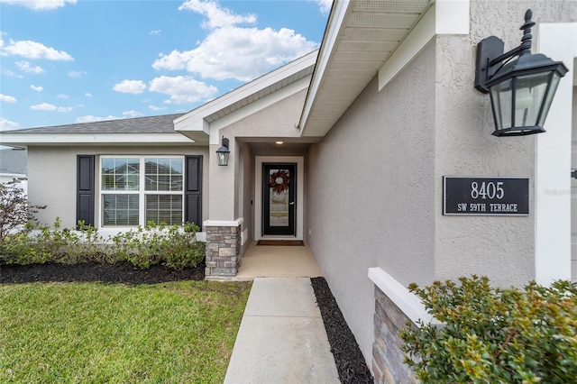 doorway to property with a lawn