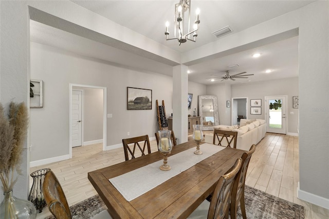 dining space with ceiling fan with notable chandelier