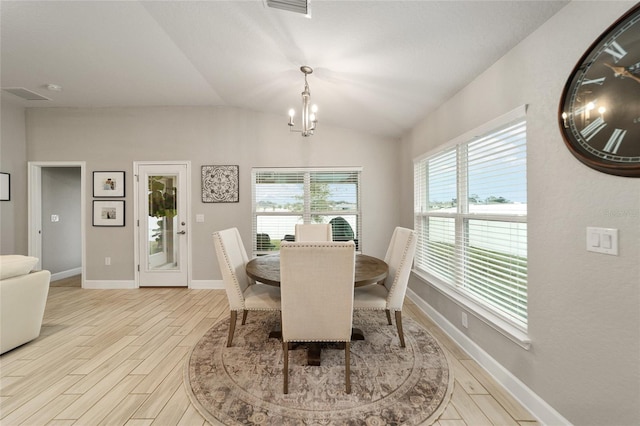 dining space with an inviting chandelier, light wood-type flooring, and vaulted ceiling