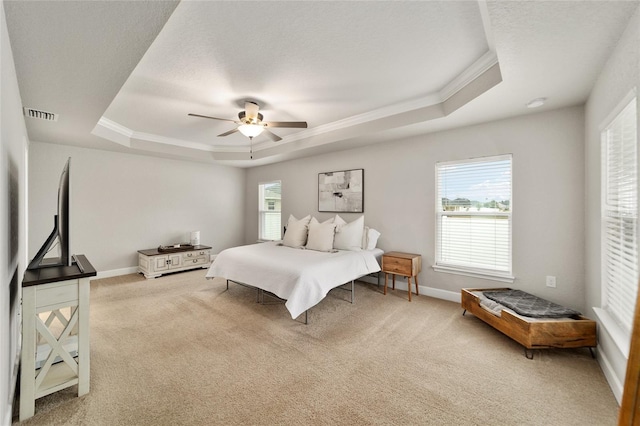 carpeted bedroom featuring a raised ceiling, ceiling fan, and crown molding