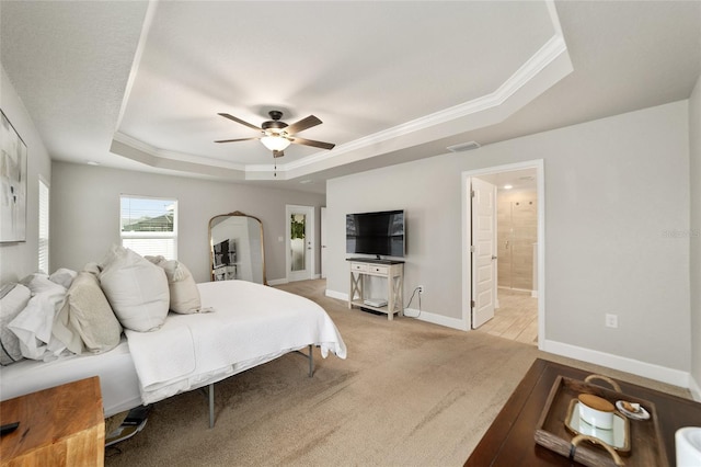 carpeted bedroom with connected bathroom, a raised ceiling, ceiling fan, and ornamental molding