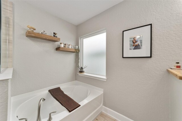 bathroom featuring a healthy amount of sunlight and a washtub