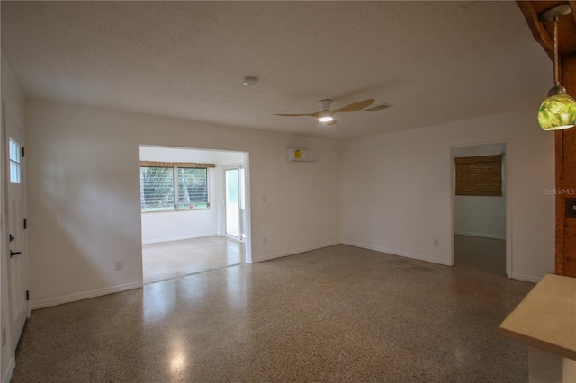 empty room featuring ceiling fan, a textured ceiling, and an AC wall unit