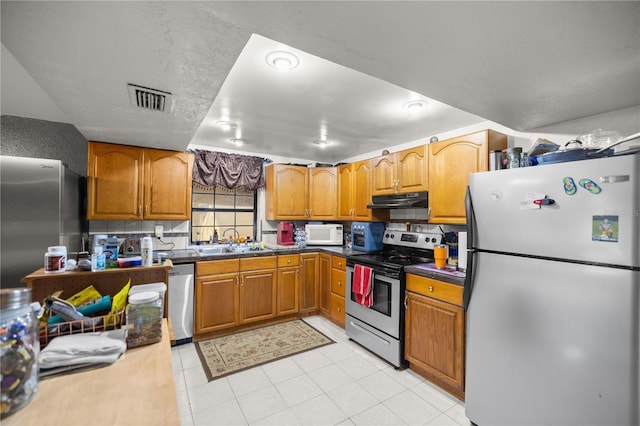 kitchen with stainless steel appliances, decorative backsplash, and sink