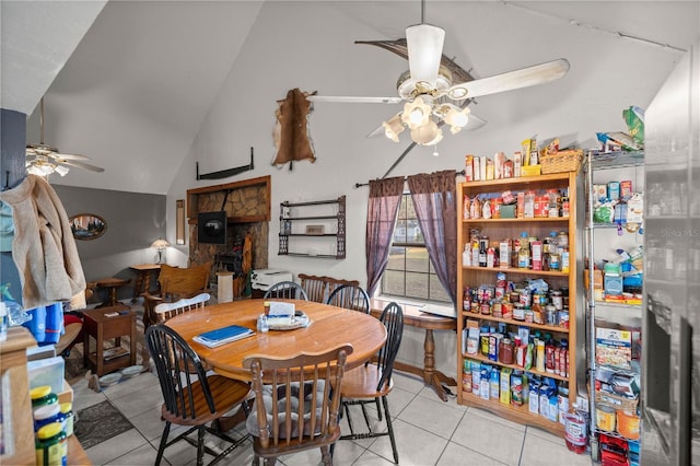 tiled dining space featuring lofted ceiling and ceiling fan