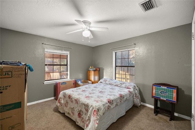 bedroom with ceiling fan, a textured ceiling, and carpet flooring