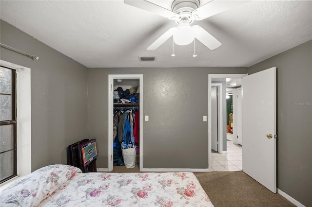 carpeted bedroom with a textured ceiling, ceiling fan, a closet, and heating unit