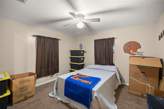 carpeted bedroom with ceiling fan and a textured ceiling