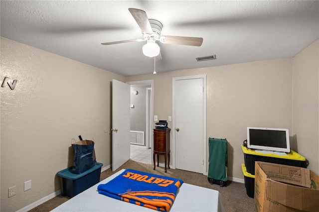 bedroom featuring a textured ceiling, carpet floors, and ceiling fan