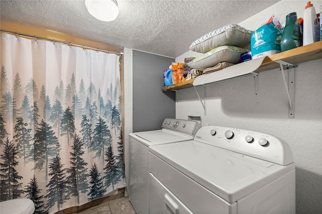 laundry area with washer and dryer and a textured ceiling