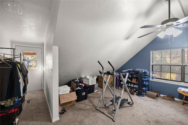 workout area with carpet flooring, a textured ceiling, ceiling fan, and vaulted ceiling