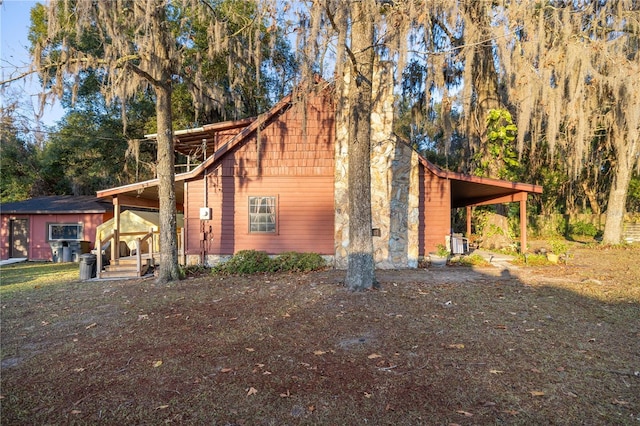 view of property exterior with cooling unit and a carport