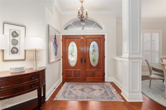 foyer entrance featuring an inviting chandelier, ornamental molding, and wood-type flooring