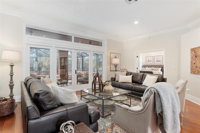 living room with crown molding, hardwood / wood-style floors, and french doors