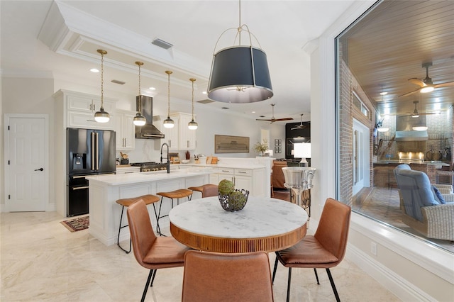 dining area with crown molding and ceiling fan