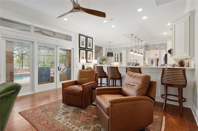 living area featuring crown molding, sink, ceiling fan, and dark hardwood / wood-style flooring