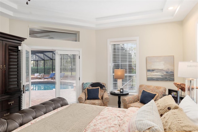 bedroom with access to exterior and a raised ceiling