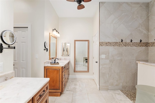 bathroom with ceiling fan, vanity, and tiled shower