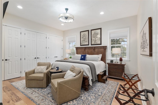 bedroom featuring two closets and light hardwood / wood-style floors