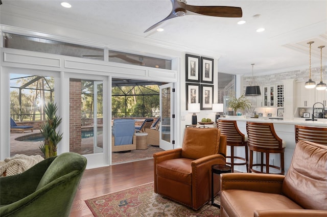 living room featuring crown molding, ceiling fan, and hardwood / wood-style flooring