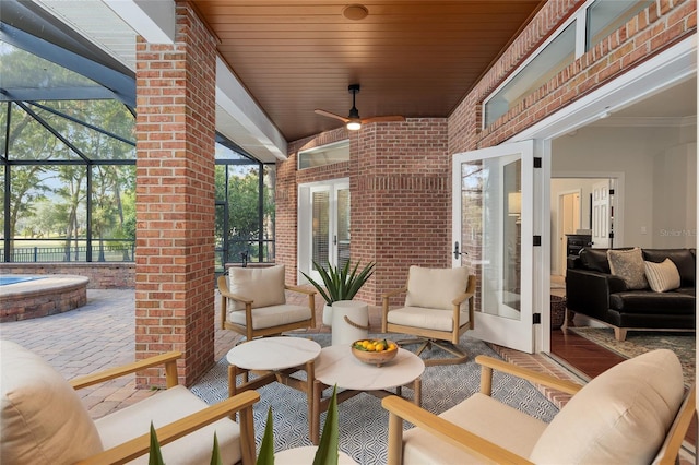 view of patio / terrace featuring an outdoor living space, french doors, ceiling fan, and glass enclosure