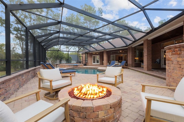 exterior space with an outdoor fire pit, a pool with hot tub, and glass enclosure