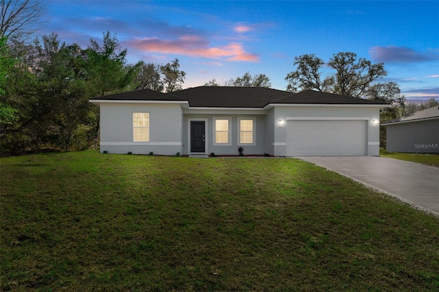 ranch-style house featuring a yard and a garage