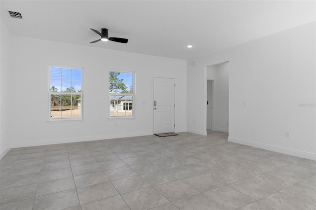 spare room with ceiling fan and light tile patterned floors