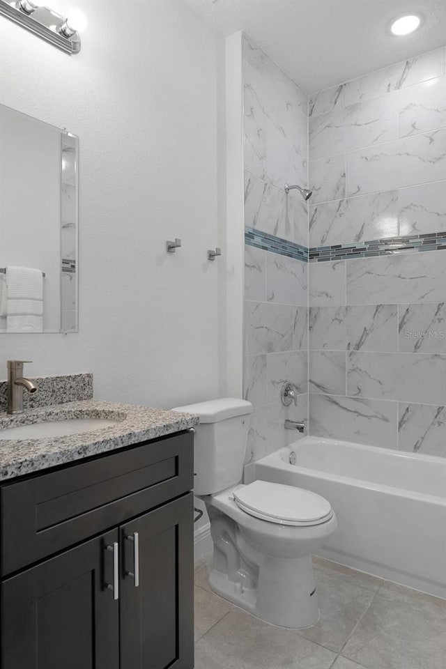 full bathroom with toilet, vanity, tile patterned floors, and tiled shower / bath