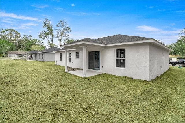 rear view of house with a lawn and a patio area