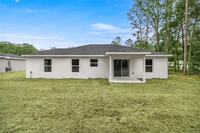 rear view of house with a patio area, a yard, and central AC