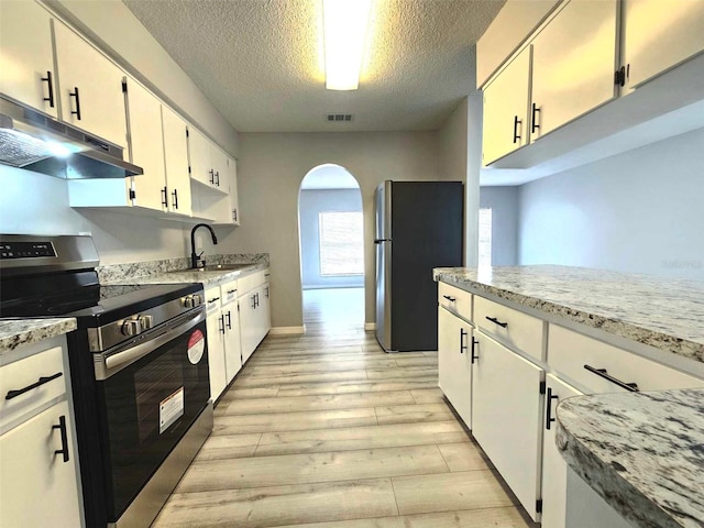 kitchen featuring sink, white cabinets, a textured ceiling, light stone countertops, and appliances with stainless steel finishes