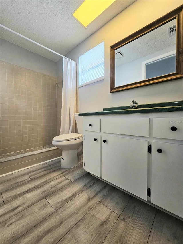 bathroom with toilet, vanity, hardwood / wood-style flooring, and a shower with curtain