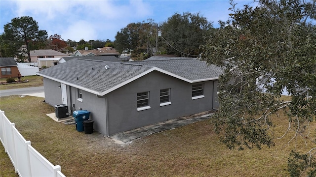 view of side of property featuring cooling unit and a yard