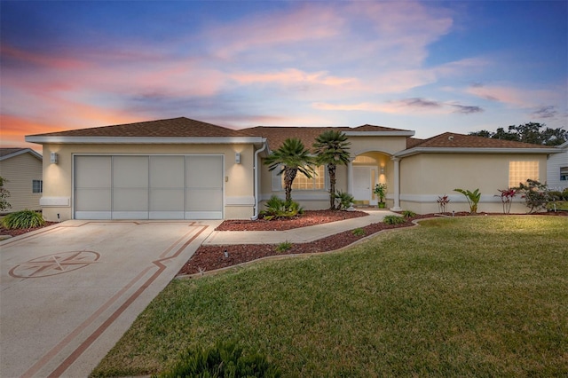 view of front of property featuring a garage and a lawn