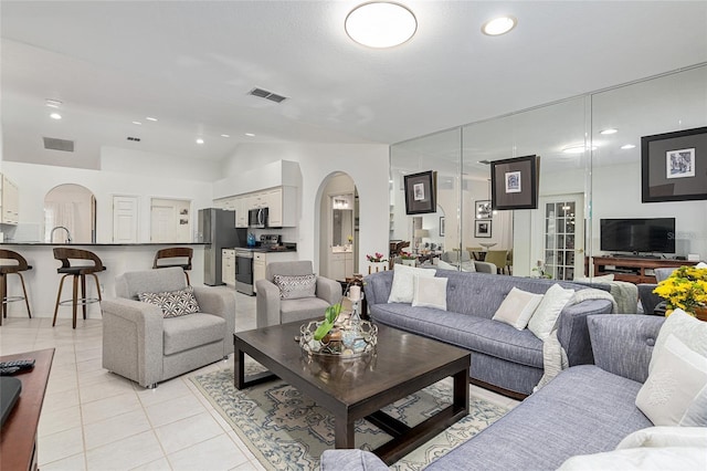 tiled living room with sink and vaulted ceiling