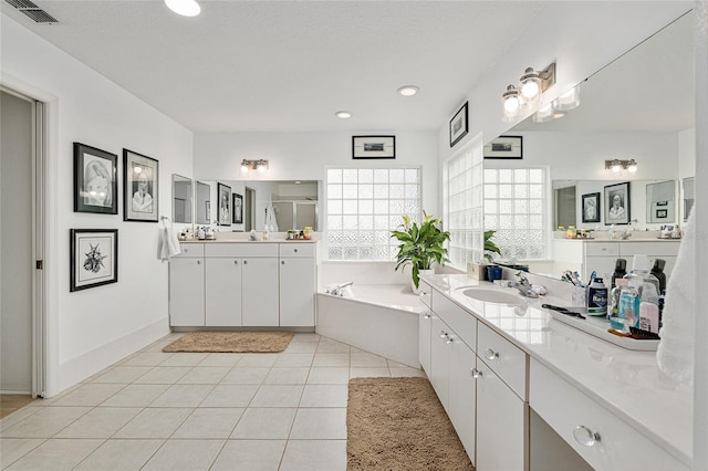 bathroom with tile patterned flooring, a tub to relax in, and vanity