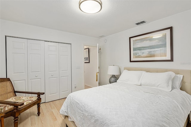 bedroom with a closet and light hardwood / wood-style flooring